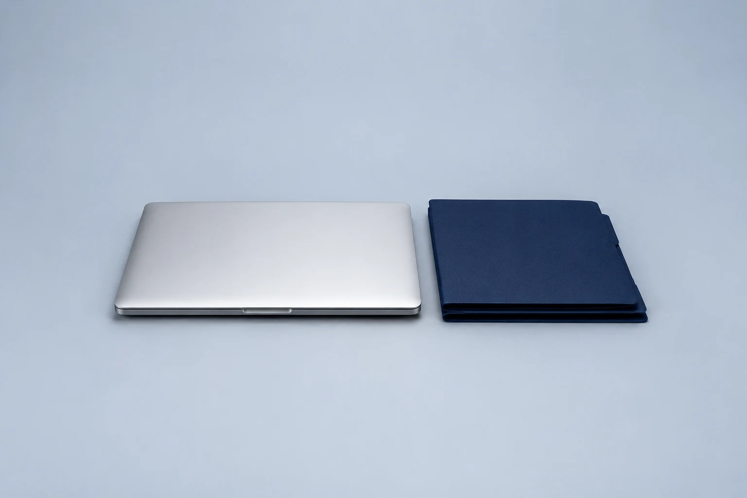 Laptop beside a stack of navy folders